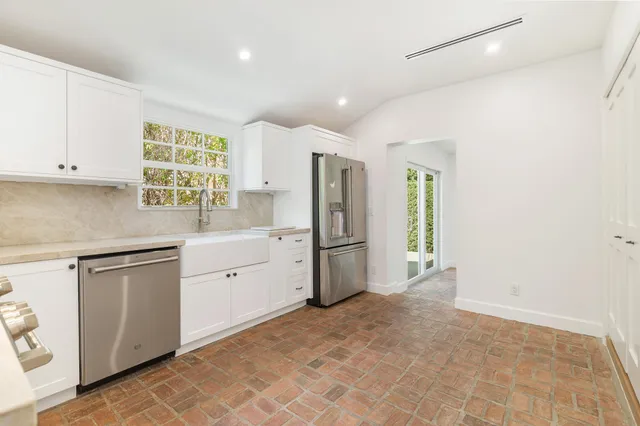 a kitchen with white cabinets and white appliances