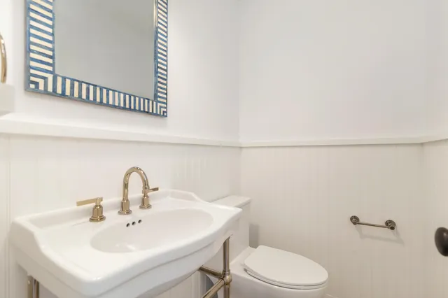 a bathroom with a sink a toilet and a mirror