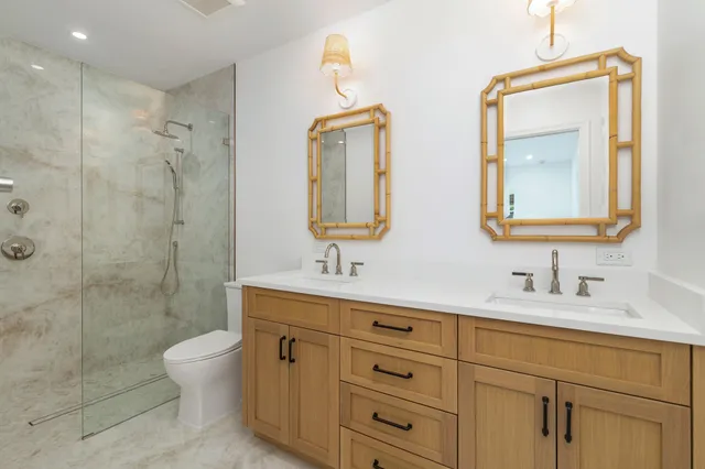 a bathroom with a double vanity sink mirror and toilet