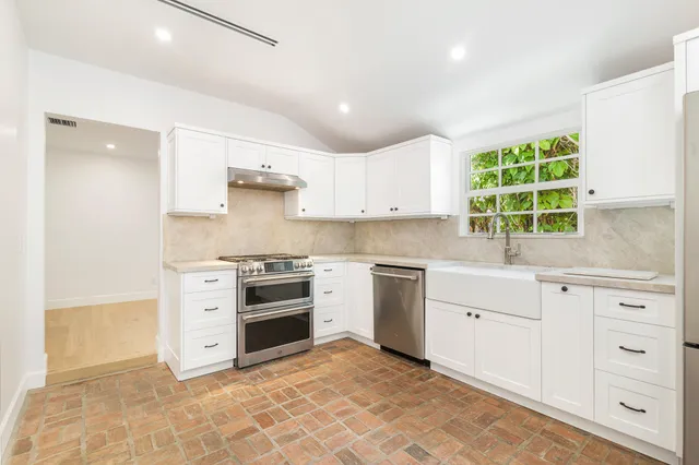 a kitchen with granite countertop a stove a sink and a microwave