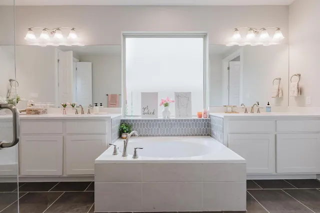 a bathroom with a sink vanity tub and a mirror