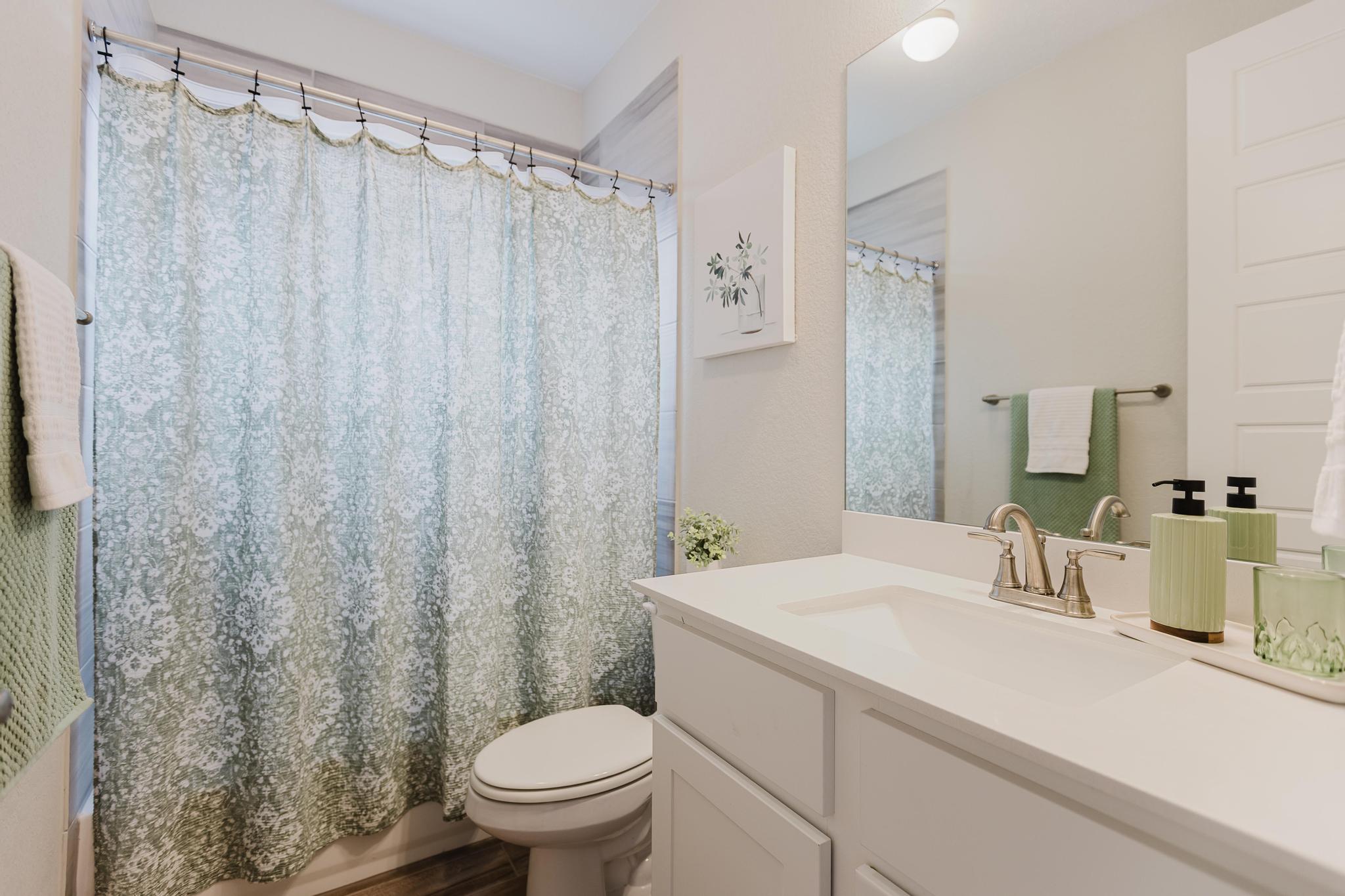 1104 Lickety Lane Georgetown, TX 78633 - Photo 24 of 40 a bathroom with a sink a toilet and shower curtain