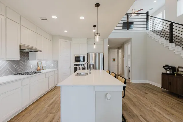 a large kitchen with kitchen island a sink stainless steel appliances and cabinets