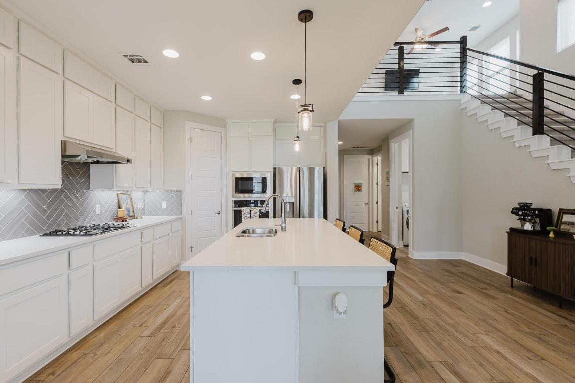 1104 Lickety Lane Georgetown, TX 78633 - Photo 8 of 40 a large kitchen with kitchen island a sink stainless steel appliances and cabinets
