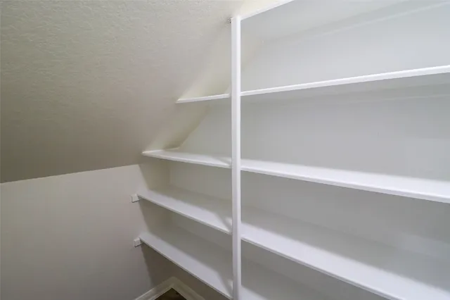 a view of walk in closet with empty racks