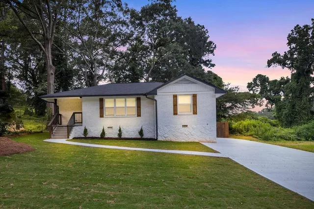 a view of a house with a yard and sitting area