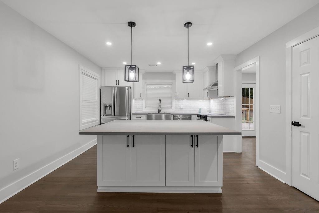 2219 Sharon Way Decatur, GA 30032 - Photo 3 of 23 a kitchen with kitchen island a sink a center island stainless steel appliances and cabinets