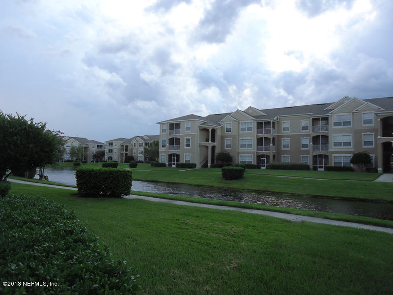 7990 Baymeadows Road East, Unit 1023 Jacksonville, FL 32256 - Photo 37 of 39 a view of a big house with a big yard and large trees
