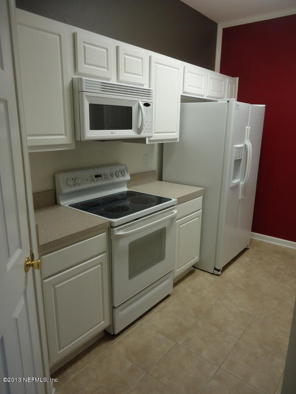 7990 Baymeadows Road East, Unit 1023 Jacksonville, FL 32256 - Photo 7 of 39 a kitchen with stainless steel appliances white cabinets white and a refrigerator