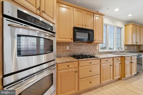 a kitchen with granite countertop white cabinets stainless steel appliances and a sink