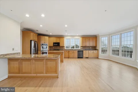 a large kitchen with stainless steel appliances granite countertop a large counter top and a stove top oven