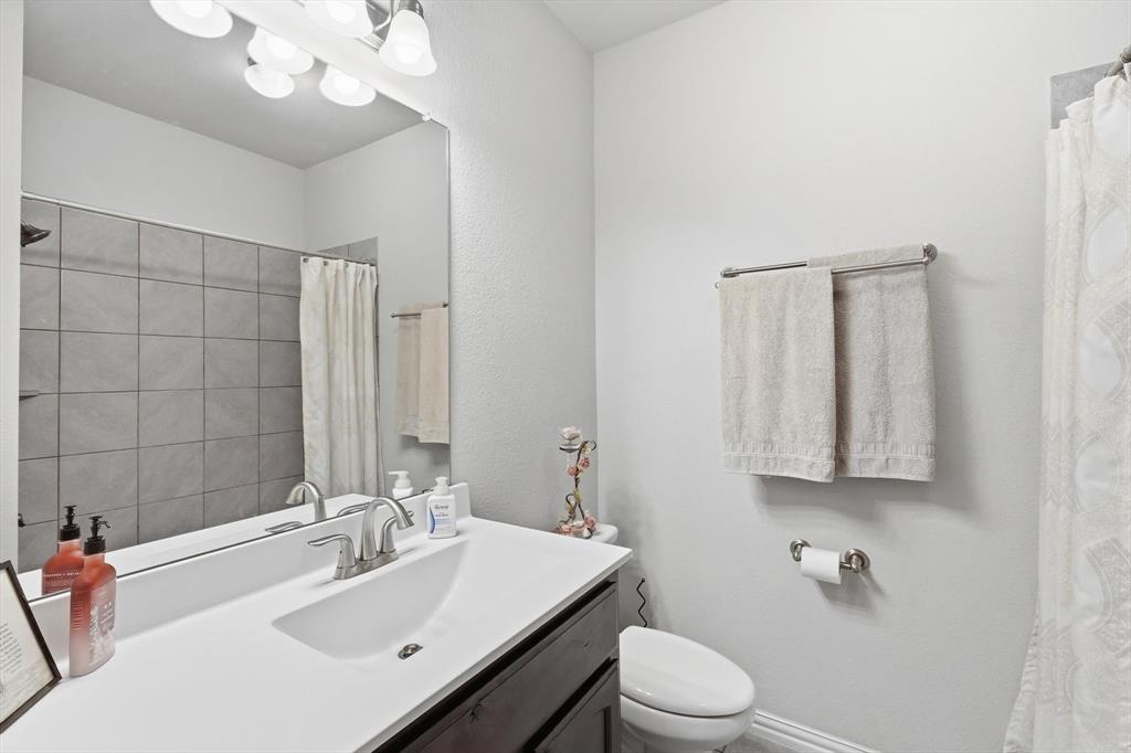 113 Heather Lane Decatur, TX 76234 - Photo 26 of 32 a bathroom with a sink a toilet and shower curtain