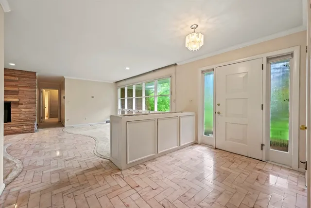 a view of an empty room with window and cabinet