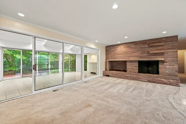 a view of an empty room with a fireplace and a large window