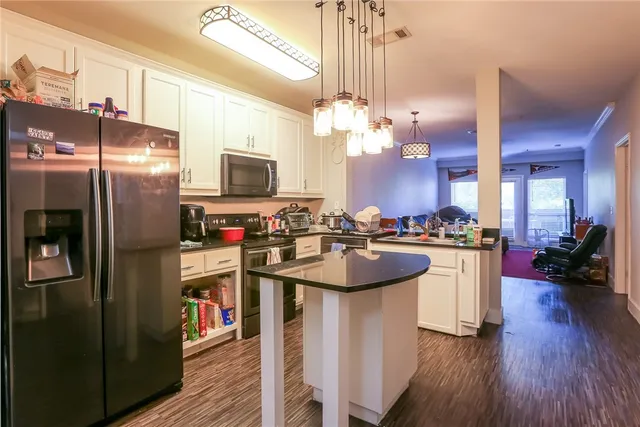 a kitchen with kitchen island a sink appliances and cabinets