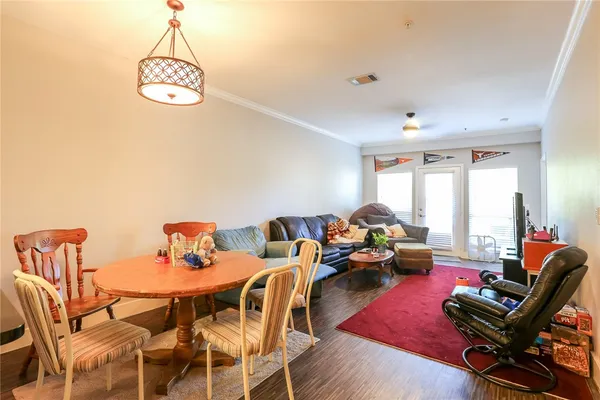 a living room with furniture a rug chandelier and a window