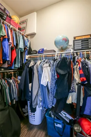 a view of walk in closet with clothes and shoes