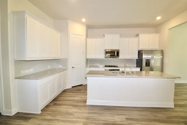 a kitchen with kitchen island a sink a stove and a refrigerator