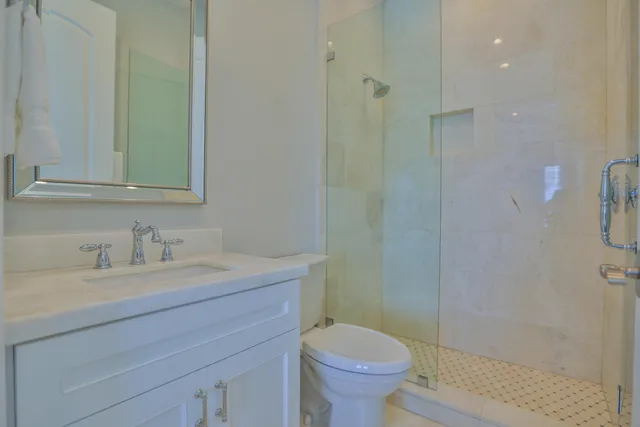 a bathroom with a granite countertop sink a toilet and a mirror