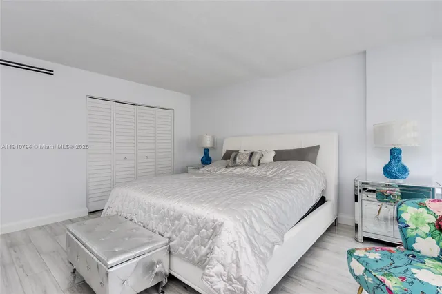 a bedroom with a large bed and a night stand