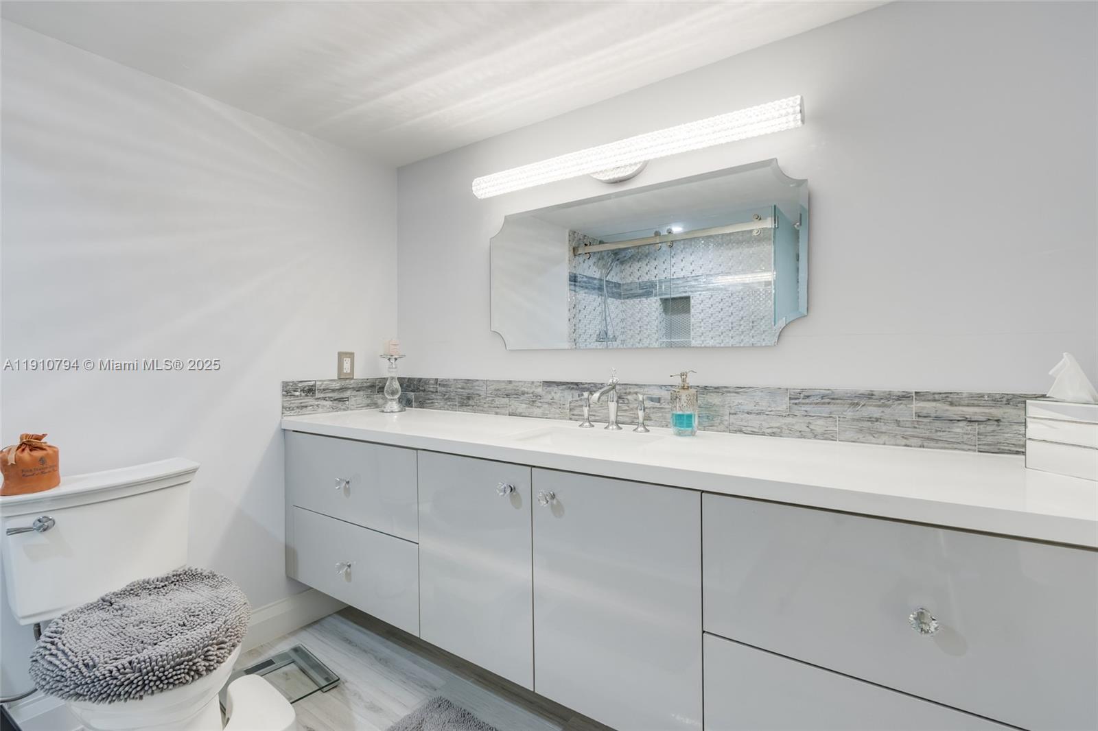 1200 South Ocean Boulevard, Unit 9F Boca Raton, FL 33432 - Photo 20 of 55 a bathroom with a granite countertop sink and a mirror