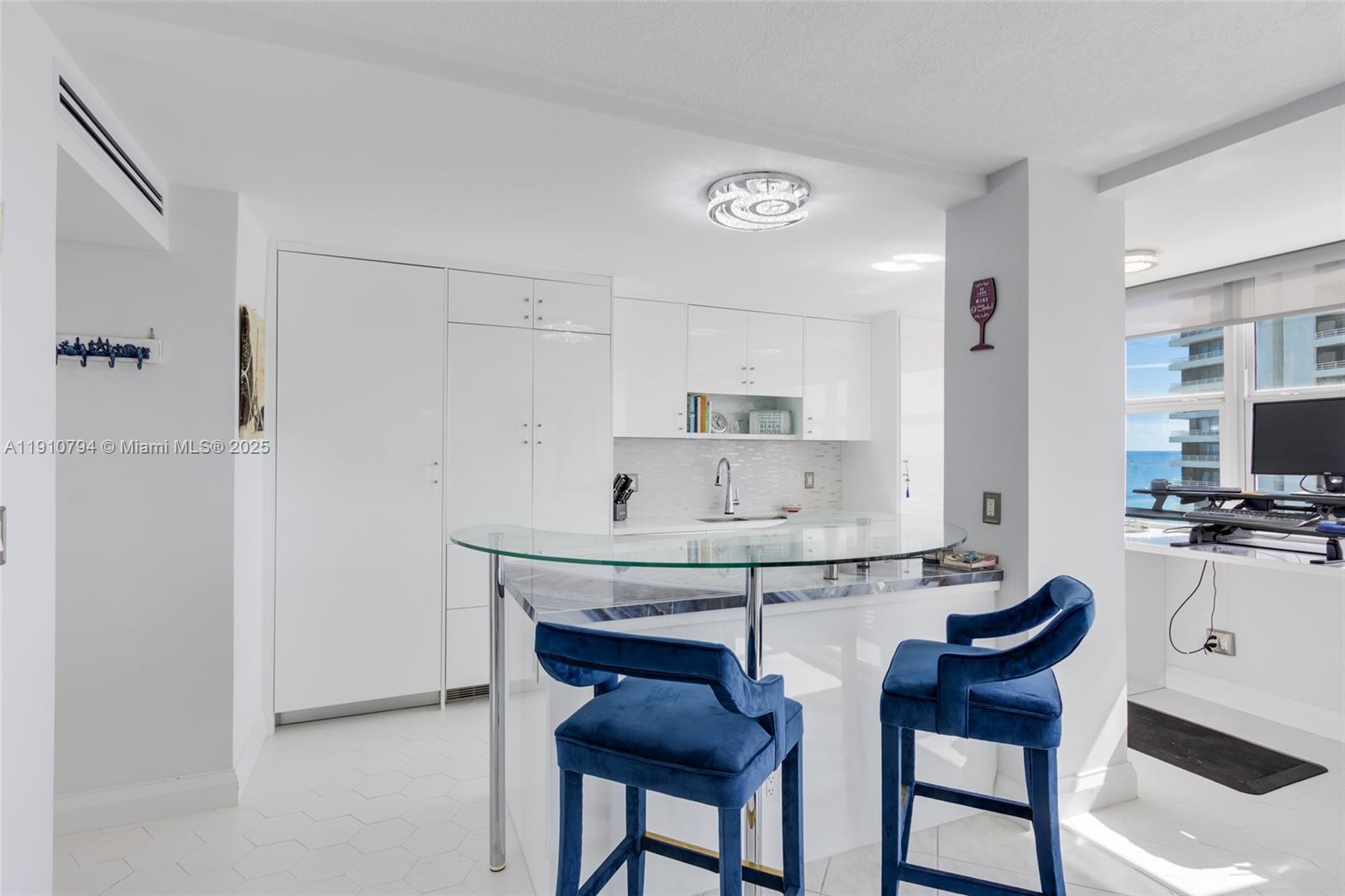 1200 South Ocean Boulevard, Unit 9F Boca Raton, FL 33432 - Photo 4 of 55 a kitchen with stainless steel appliances a table and chairs in it