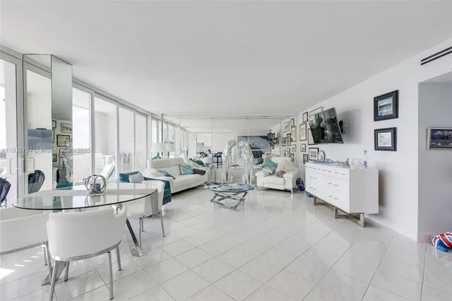 a living room with furniture a dining table and a potted plant