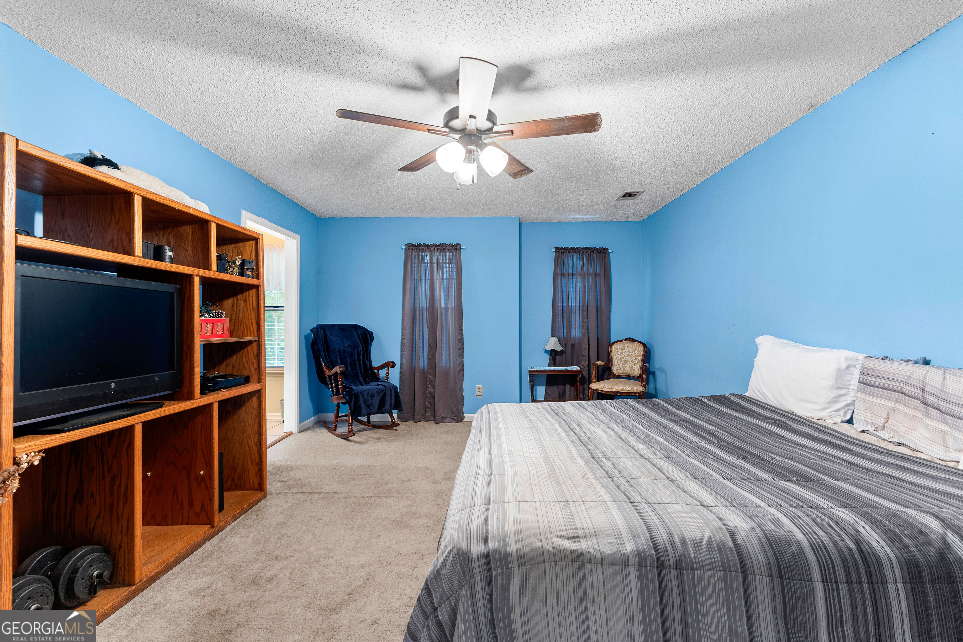 145 Greison Trail Newnan, GA 30263 - Photo 15 of 28 a bedroom with a bed and a flat tv screen on dresser