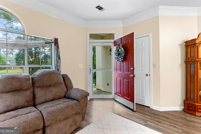 a living room with furniture and a floor to ceiling window