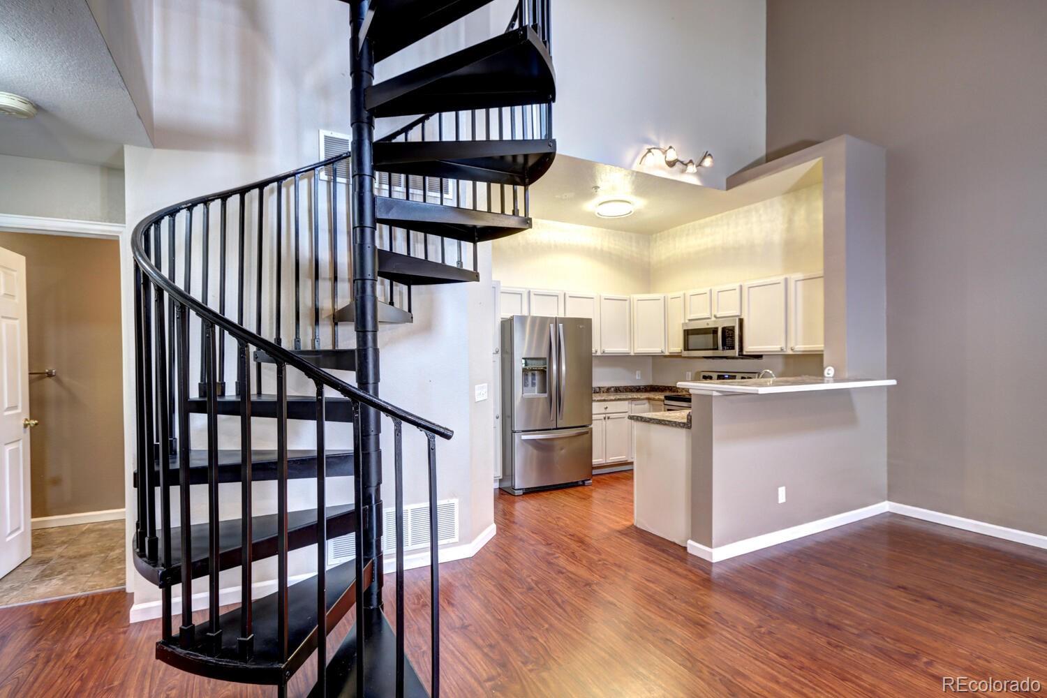 8707 East Florida Avenue, Unit 304 Denver, CO 80247 - Photo 1 of 26 a view of kitchen and empty room with wooden floor
