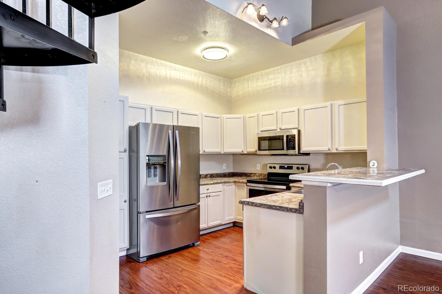 8707 East Florida Avenue, Unit 304 Denver, CO 80247 - Photo 12 of 26 a kitchen with stainless steel appliances a refrigerator stove and microwave