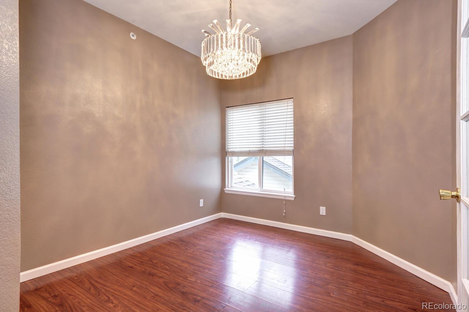8707 East Florida Avenue, Unit 304 Denver, CO 80247 - Photo 15 of 26 an empty room with wooden floor chandelier and windows