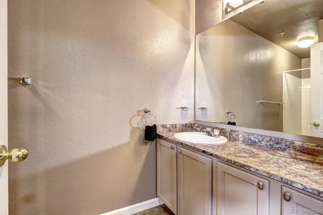 a bathroom with a granite countertop sink and a mirror