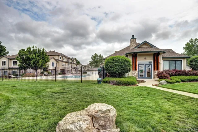 a backyard of a house with table and chairs plants and large trees