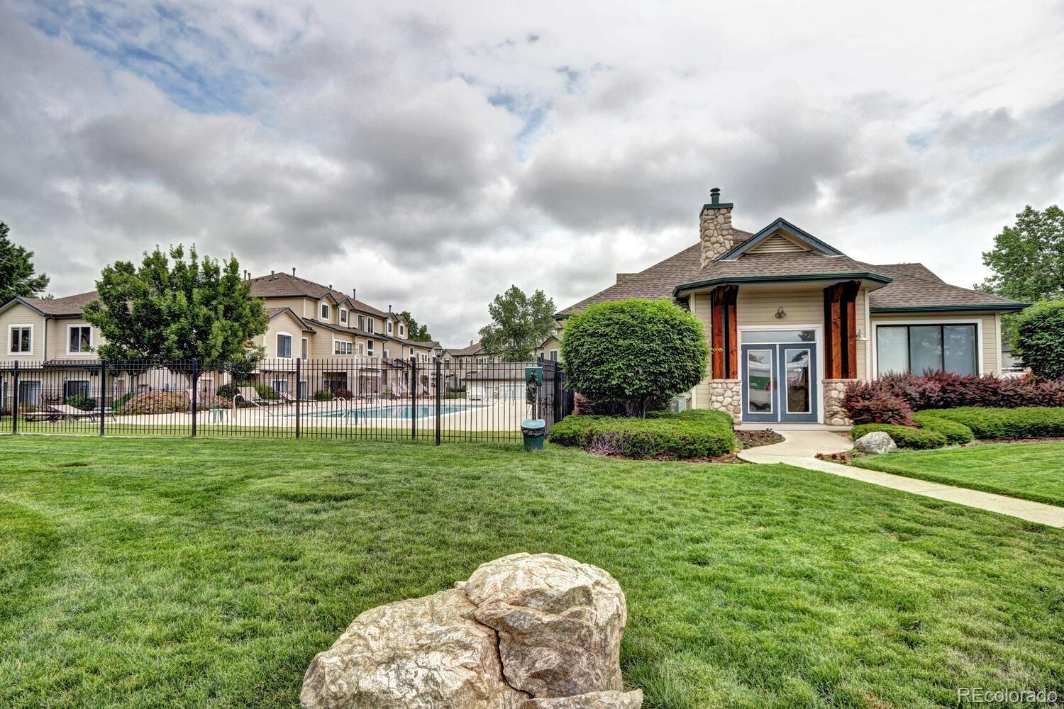 8707 East Florida Avenue, Unit 304 Denver, CO 80247 - Photo 25 of 26 a backyard of a house with table and chairs plants and large trees