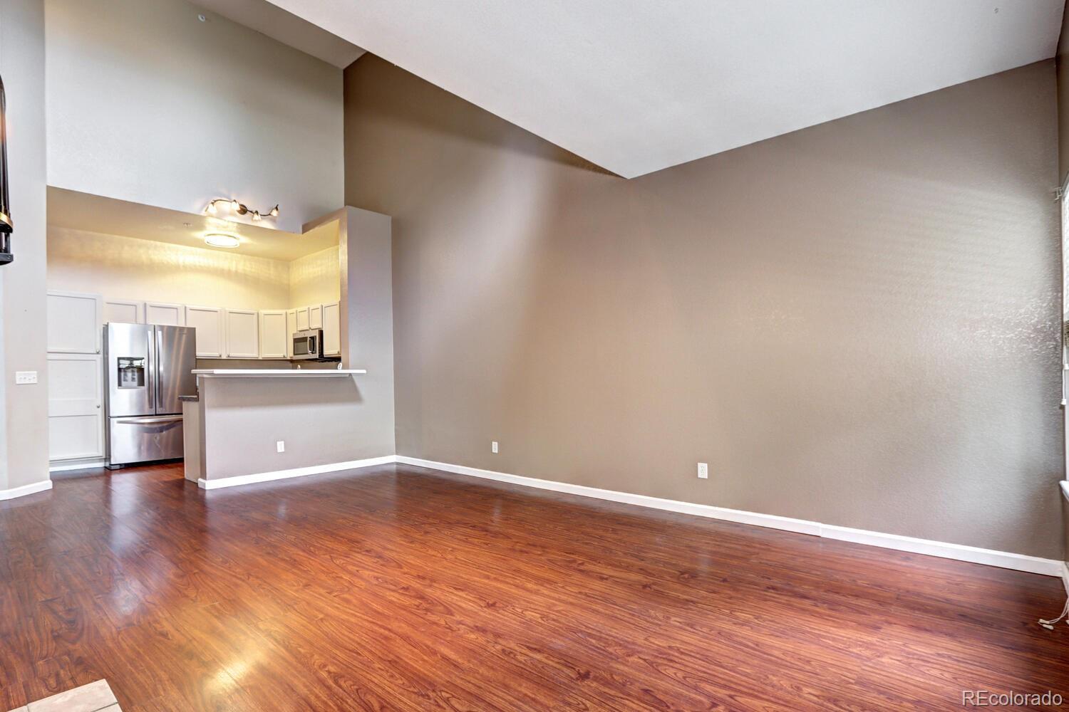 8707 East Florida Avenue, Unit 304 Denver, CO 80247 - Photo 5 of 26 a view of a kitchen with wooden floor and a refrigerator