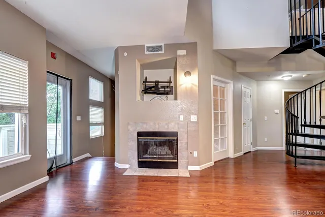 a view of a livingroom with wooden floor and a fireplace