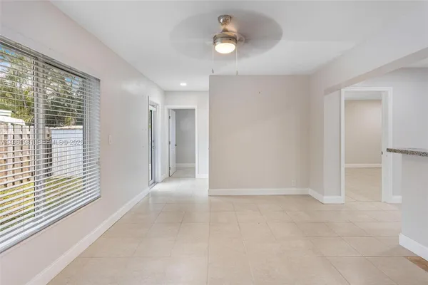 an empty room with a ceiling fan and window