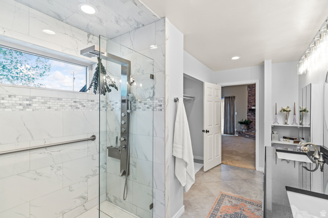 460 Omni Point Road Central Valley, UT 84754 - Photo 43 of 101 Walk-in shower featuring large format wall tile with a mosaic accent band, a multi-function shower panel, and a clear glass enclosure