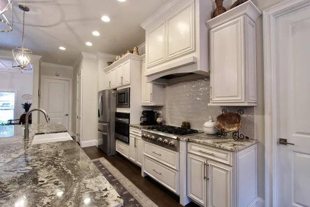 a kitchen with stainless steel appliances granite countertop a stove a sink and a refrigerator