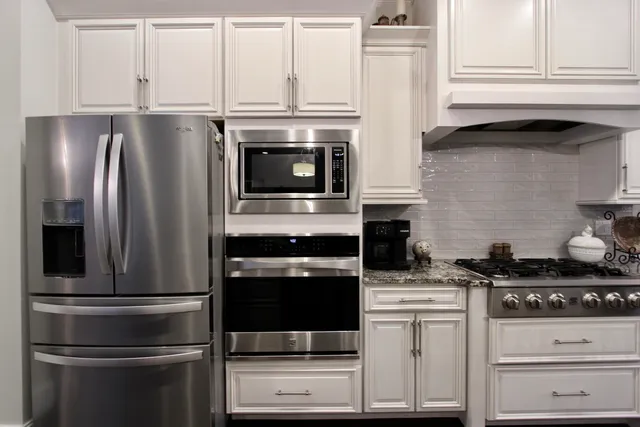 a kitchen with stainless steel appliances granite countertop a refrigerator stove and sink