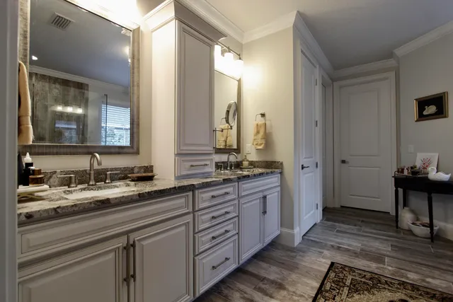 a spacious bathroom with a double vanity sink a mirror and a shower