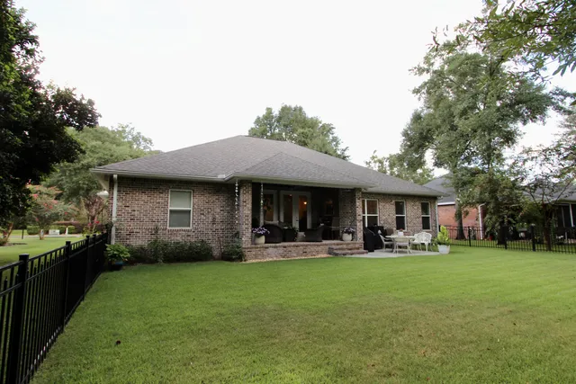 a front view of a house with a garden and trees