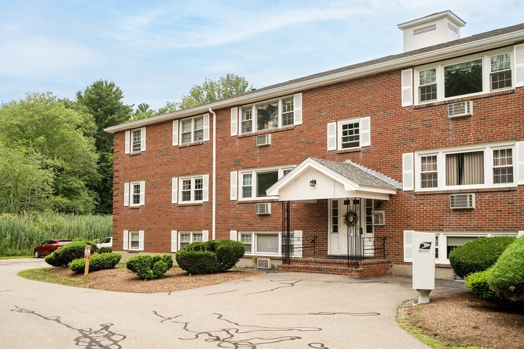 71 Stone Street, Unit 5 Walpole, MA 02081 - Photo 16 of 18 a front view of a house with yard and green space