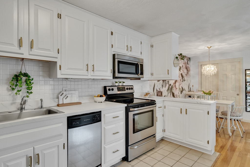 71 Stone Street, Unit 5 Walpole, MA 02081 - Photo 4 of 18 a kitchen with white cabinets stainless steel appliances and sink