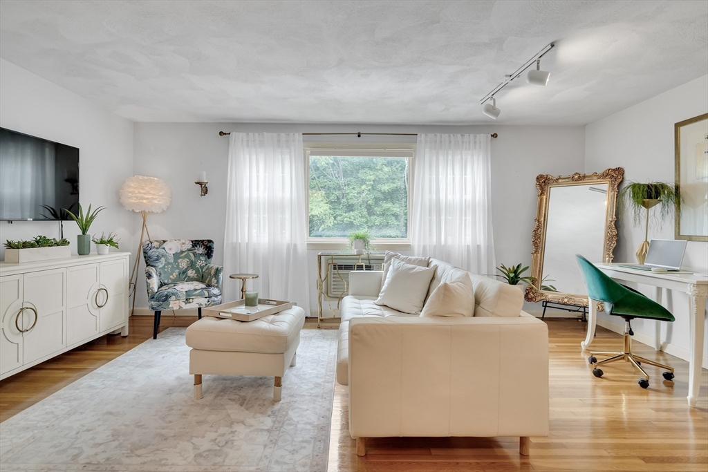 71 Stone Street, Unit 5 Walpole, MA 02081 - Photo 7 of 18 a living room with furniture a large window and a wooden floor