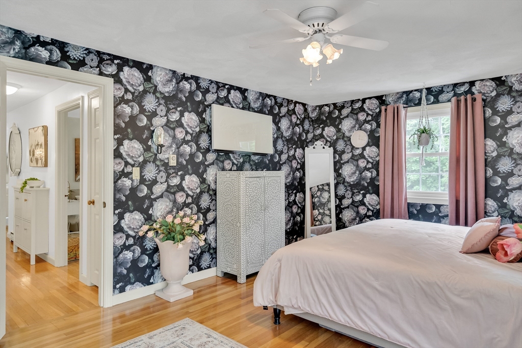 71 Stone Street, Unit 5 Walpole, MA 02081 - Photo 10 of 18 a bedroom with a large bed and a chandelier