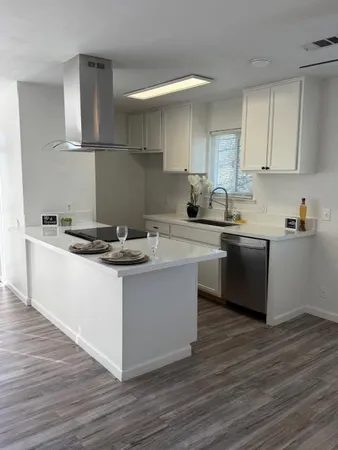 a kitchen with a sink cabinets and wooden floor