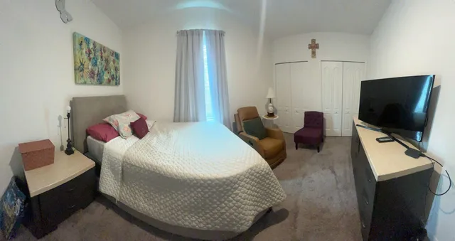 a bedroom with a bed and flat screen tv