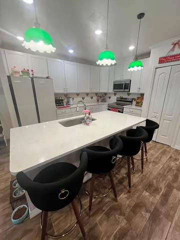a kitchen with a table chairs and white cabinets